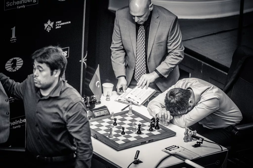 Nakamura abandona su tablero dejando a Abasov abatido, en presencia del árbitro, Aris Marghetis. Foto: Michal Walusza / FIDE