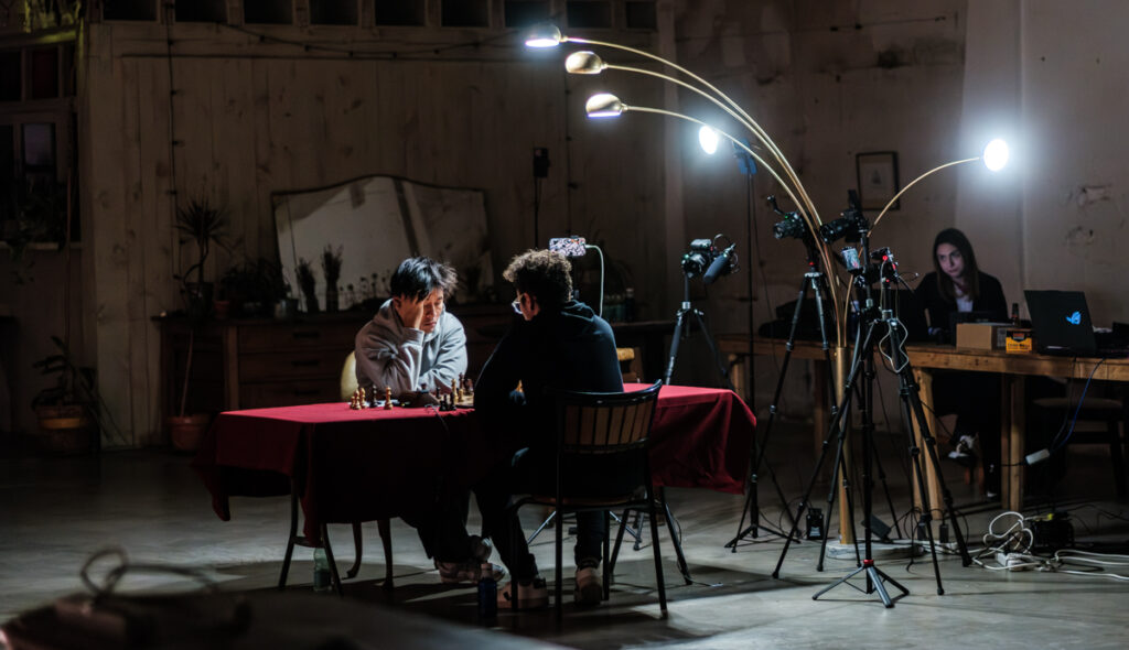 El dolor de GothamChess Gotham Song 2 Gotham-Song, un duelo con más cámaras que testigos en vivo. Se juega en la Nave Bellver de Madrid. Al fondo, la árbitra del encuentro, Mireia Ramón. Espero que no se ofenda si digo que no tuvo demasiado trabajo. Foto: FMB / Damas y Reyes